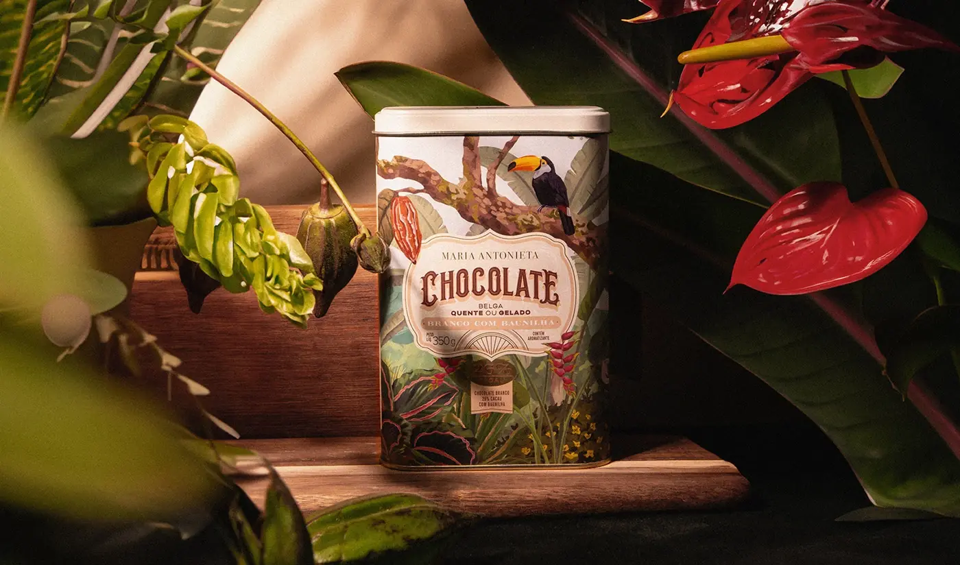 Lata de chocolate entre folhagens e antúrios